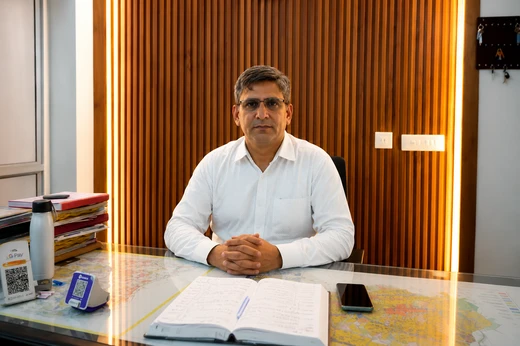 Mr. Mahender Singh sitting at desk